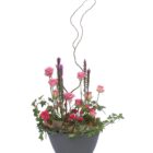 Arreglo de flores naturales con rosas, mini rosas, liatris y rizos en una base de cerámica.