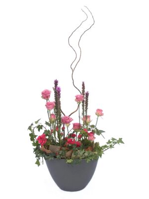 Arreglo de flores naturales con rosas, mini rosas, liatris y rizos en una base de cerámica.