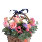 Arreglo de flores naturales con rosas, gerberas, mini rosas, bombones, gypsophila, eucalipto y follaje en una canasta.