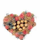 Caja rosa en forma de corazón con rosas, gypsophilas y 10 chocolates Ferrero Rocher.