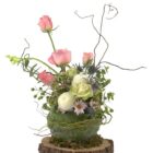 Arreglo de flores naturales con rosas, bombones, flores de Eryngium, Piocha, Curly y margaritas en una bola de eucalipto y sobre una base de tronco.