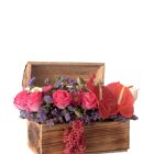 Baúl de madera con flores naturales como Matsumotos, Siempre Vivas, Rosas y Anturios.