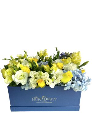 Arreglo de flores naturales con rosas, hortensias y lisianthus en caja de color azul.